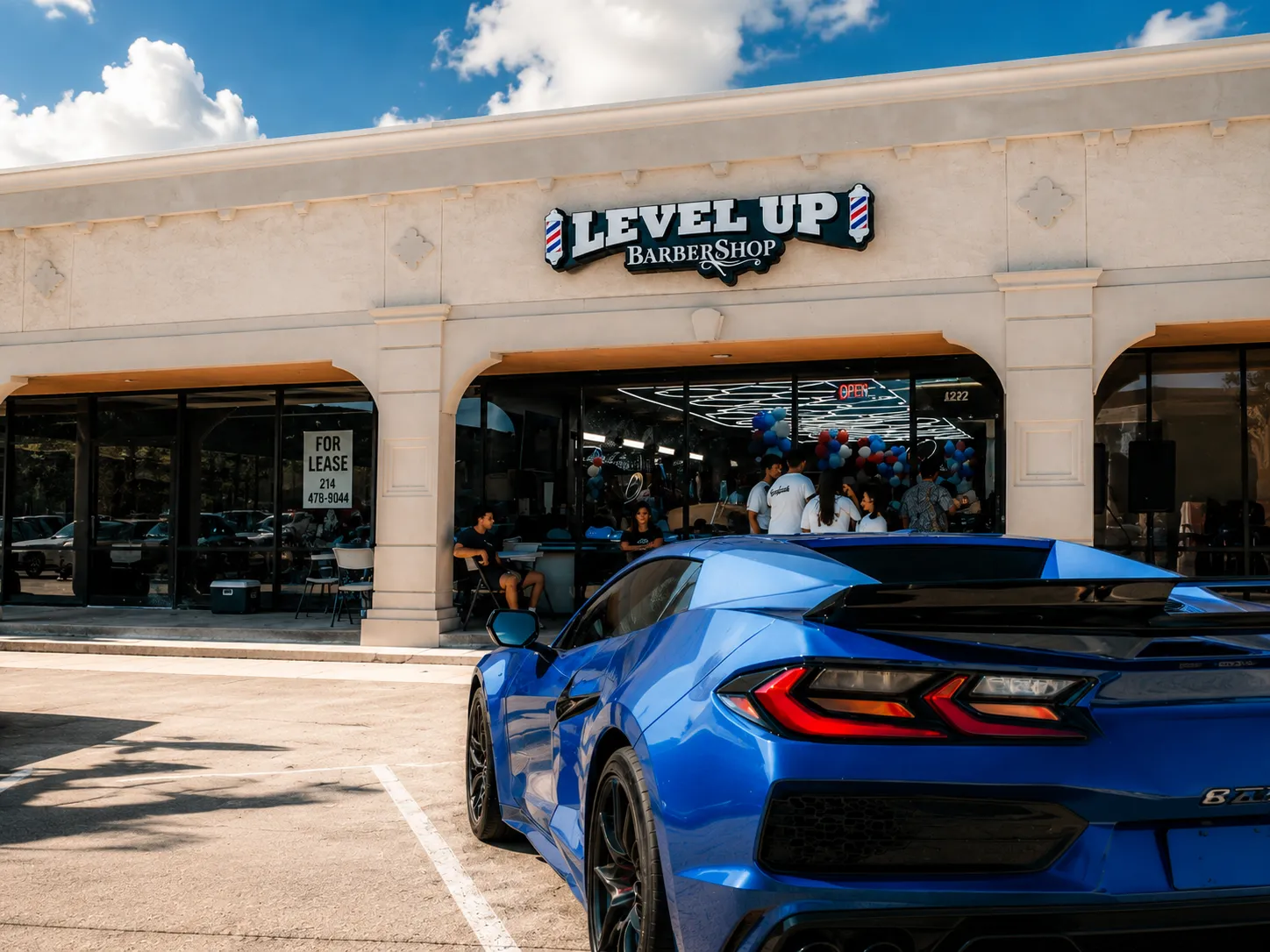 Fachada de LevelUp Barbershop con un auto deportivo azul al frente