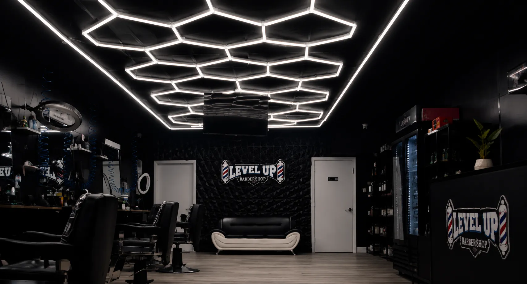 Interior de LevelUp Barbershop con iluminación hexagonal